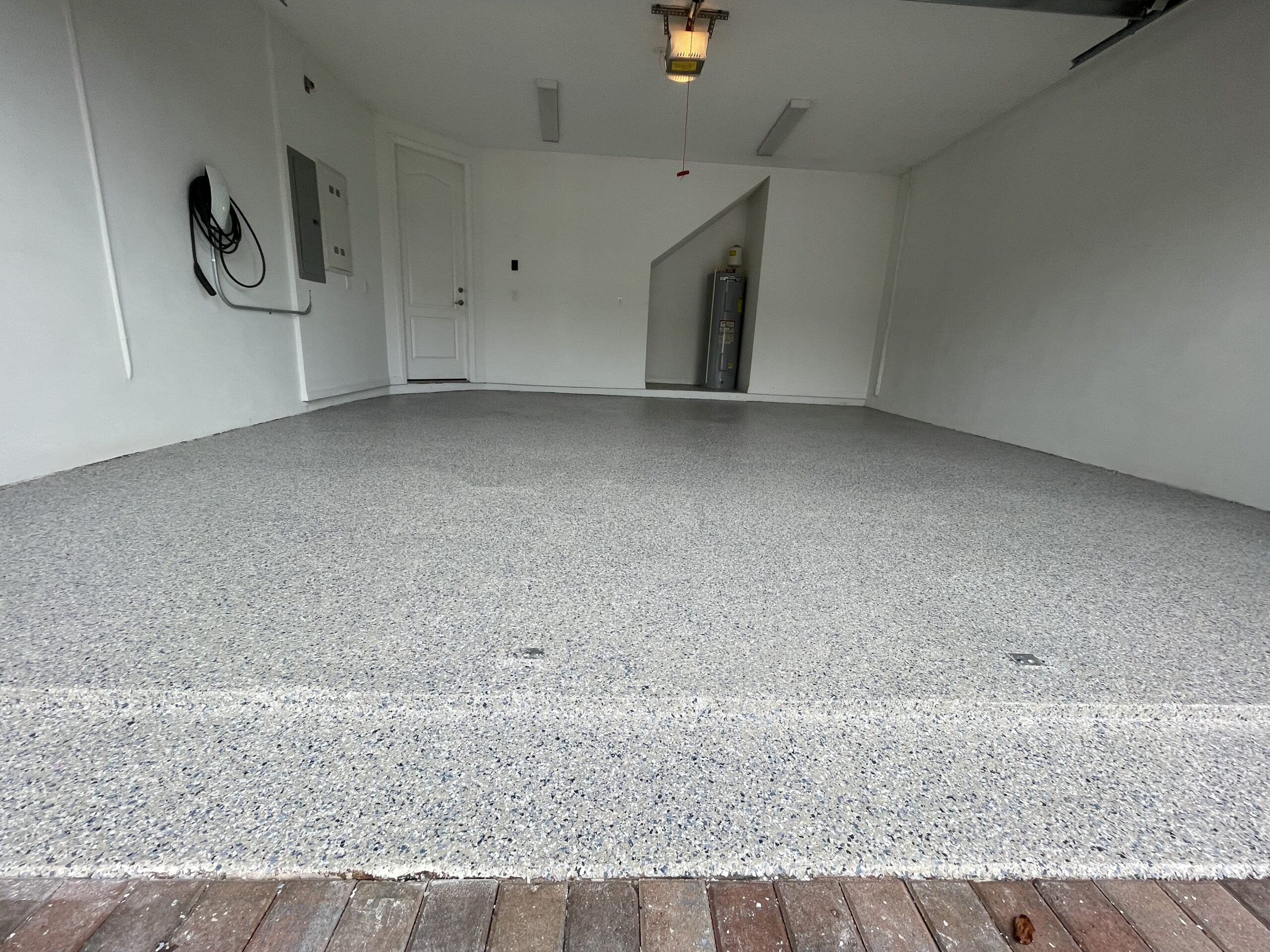 Skilled Carbon Concrete Coatings technician applying non-slip durable epoxy to a garage floor, ensuring safety and style in North Miami