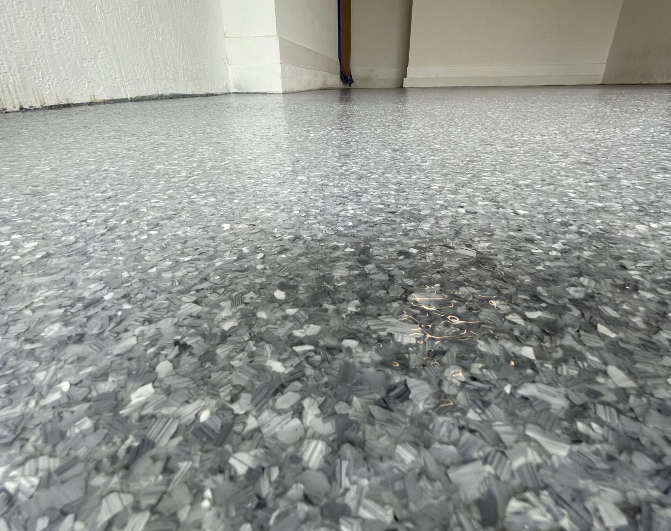Installer applying Standard Epoxy Garage Flooring inside a Palmetto Bay, FL garage with careful edge work