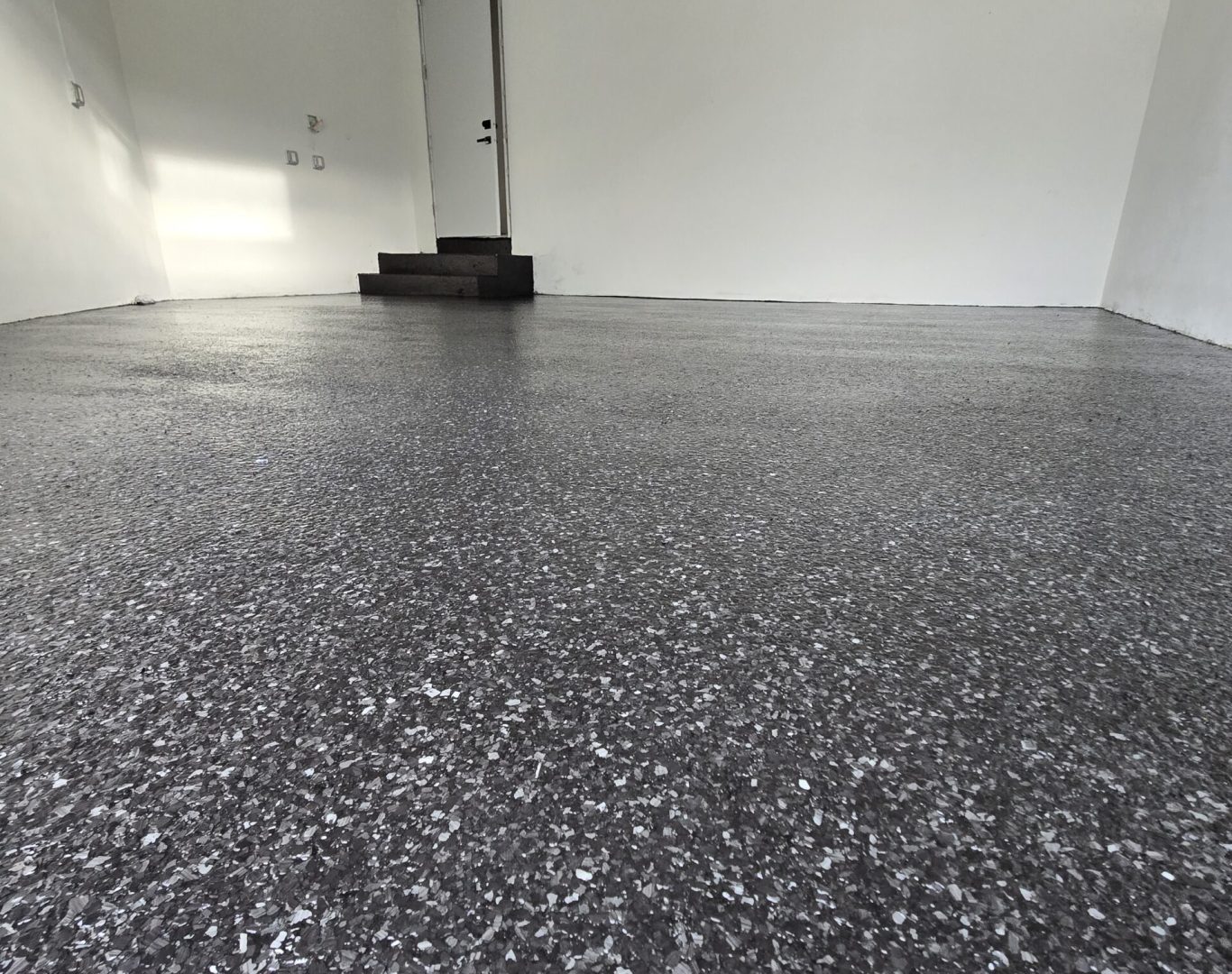 Skilled Carbon Concrete Coatings technician applying non-slip durable epoxy to a garage floor, ensuring safety and style in North Miami