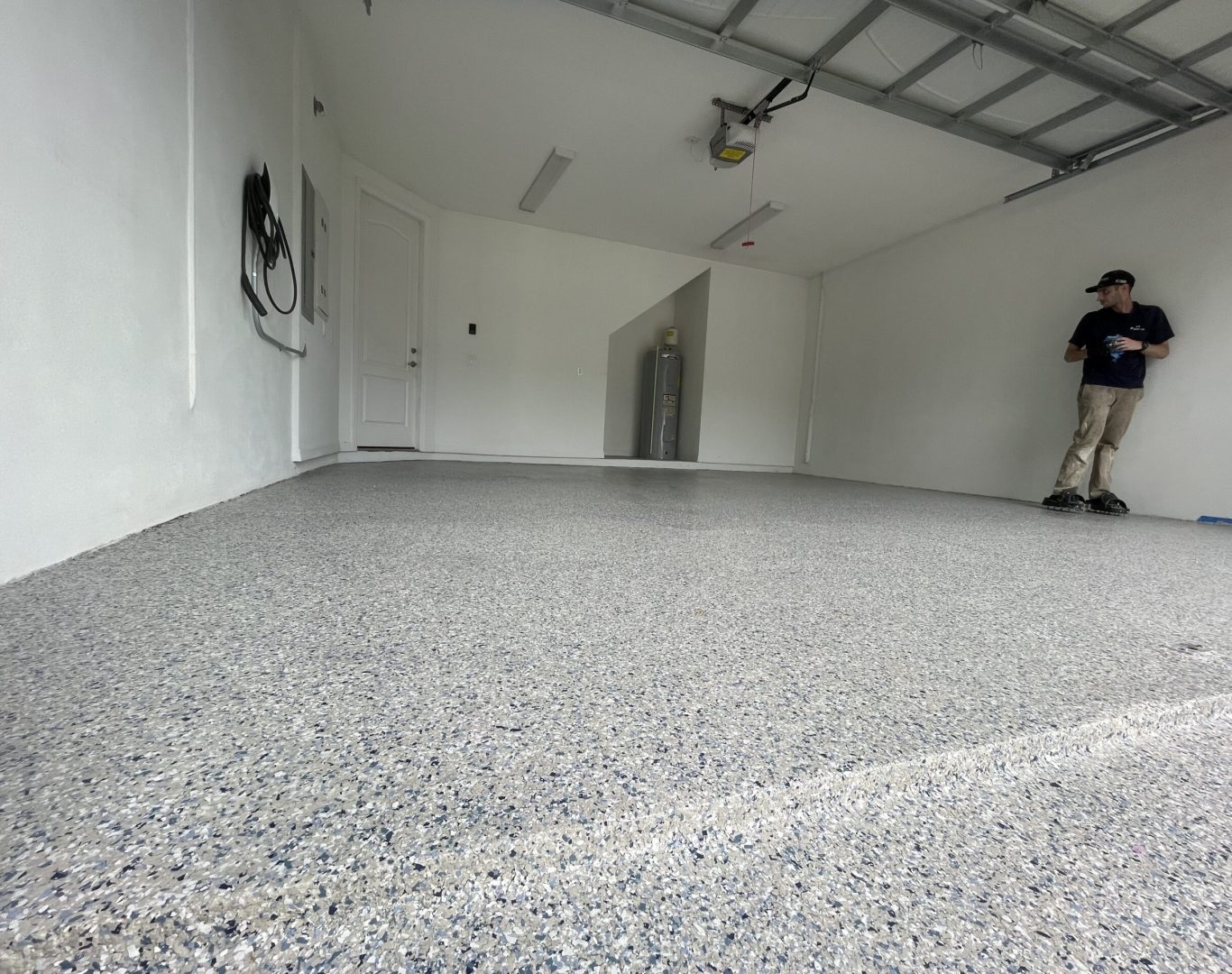 Installer applying Residential Epoxy Garage Flooring inside a Palmetto Bay, FL home garage during surface finishing
